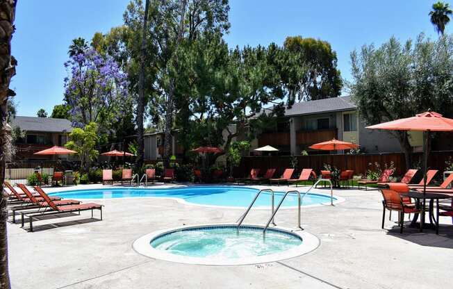 beautiful pool and spa surrounded by lounges, tables, and umbrellas. available to all residents