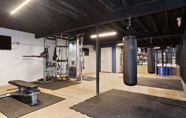 A gym with a punching bag hanging from the ceiling.