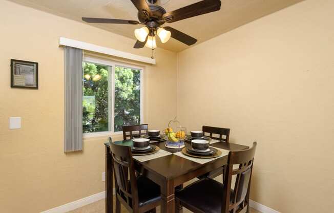 a dining room with a table and chairs and a ceiling fan