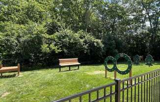 a park with two benches and a fence