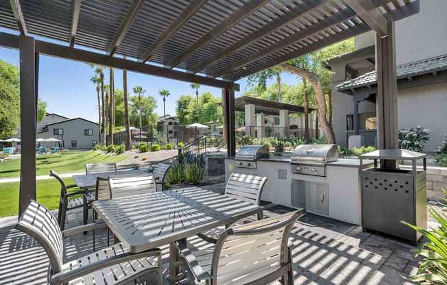 A patio with a table and chairs under a roof.