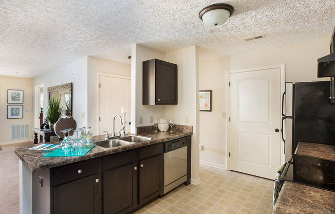modern kitchen with dark brown cabinetry and stainless steel appliances