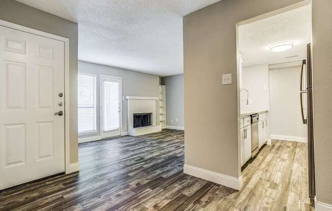 A room with a fireplace and wooden floors.