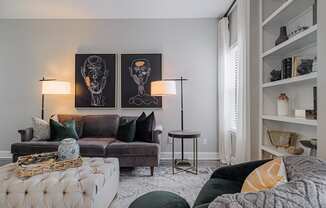 a living room with a couch and a chair and a book shelf