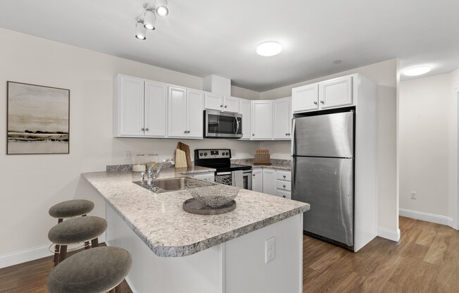 a kitchen with a granite counter top and a stainless steel refrigerator