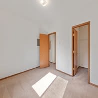 an empty room with two doors and a rug