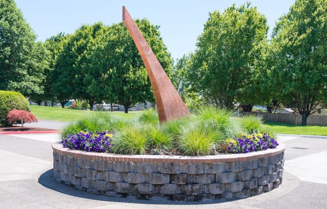 a fountain in a park with trees and a statue