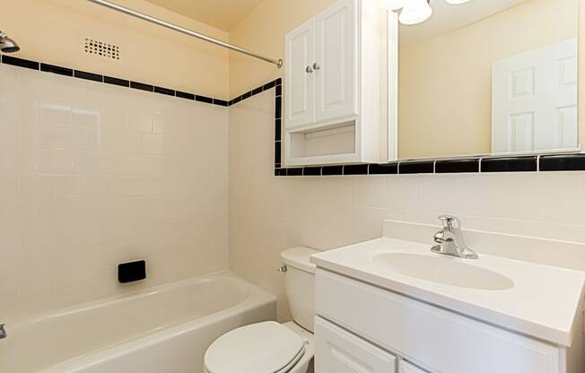 bathroom with tub, toilet, mirror, sink, medicine cabinet and tile details at penn view apartments in washington dc