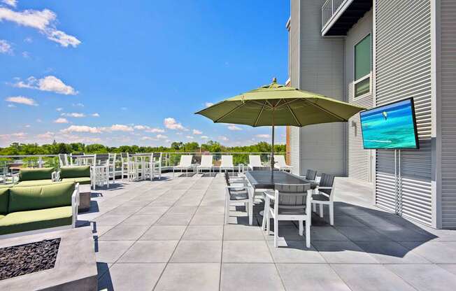 A patio with a table, chairs, and an umbrella.