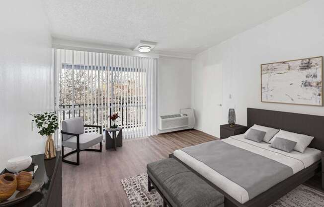 A bedroom with a large bed and a chair by a window.