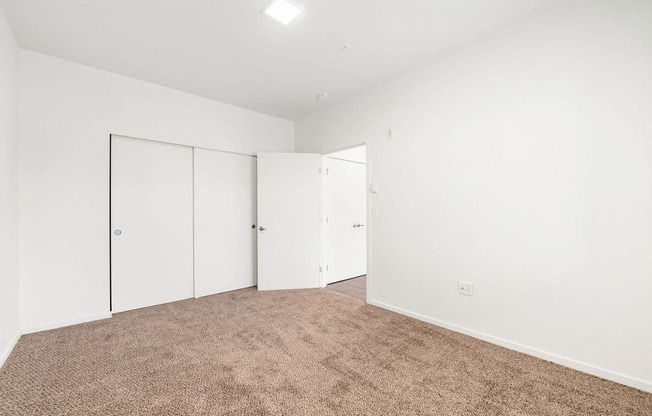 a bedroom with white walls and carpet