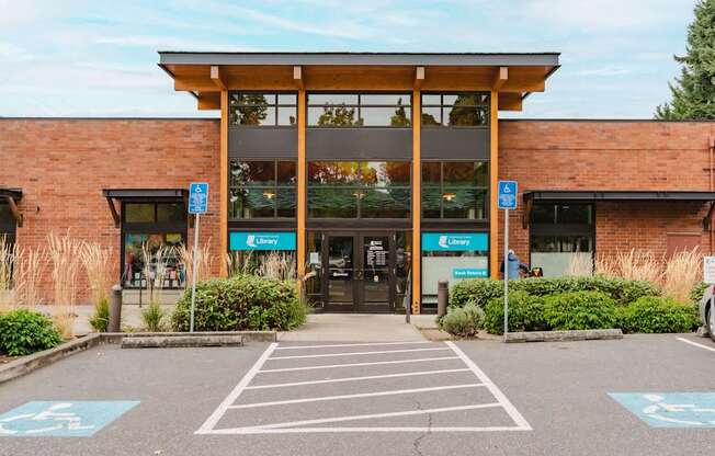 A parking lot with a building entrance and a sign that says