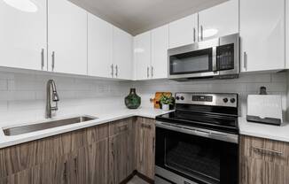 a kitchen with white cabinets and black appliances