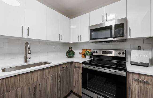 a kitchen with white cabinets and black appliances