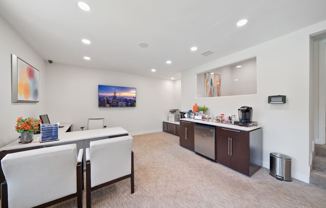 a conference room with two desks and chairs and a counter with a sink