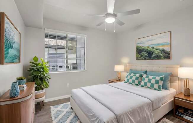 A bedroom with a large bed and a ceiling fan.