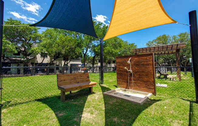 a bench and a shower in a park under umbrellas