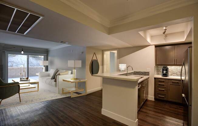 A modern kitchen with a white island and dark wood floors. at The Vista at Laguna, Laguna Niguel