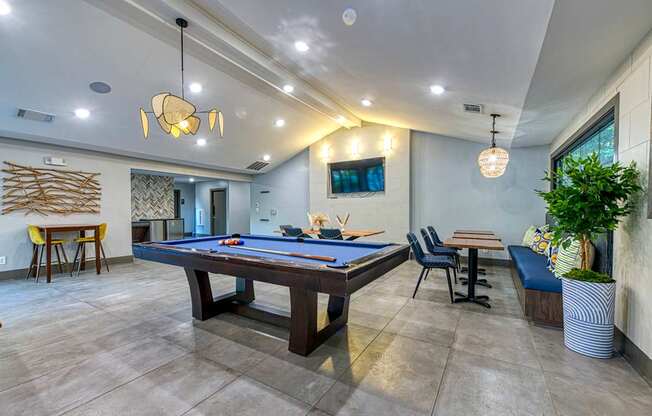 A room with a pool table and a tv mounted on the wall.