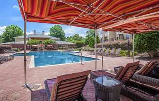 a swimming pool with chairs and umbrellas