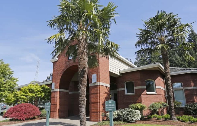 A red brick building with a palm tree in front at Wilsonville Summit Apartments, Wilsonville , Oregon
