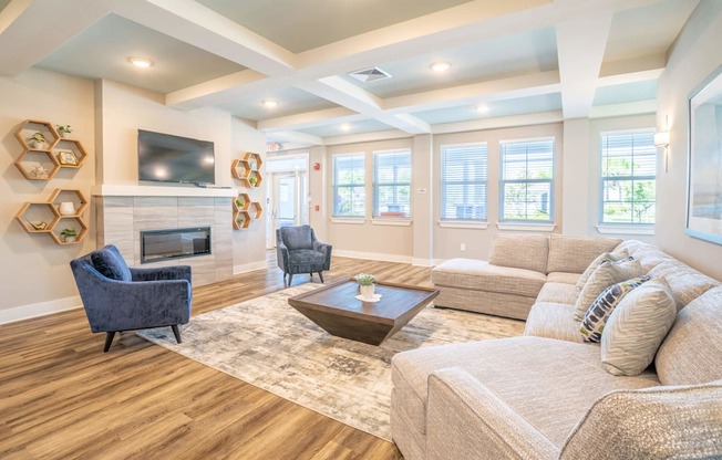 Clubhouse lounge area with a coffee table, tv and chairs at Trillium Luxury apartments in melbourne fl