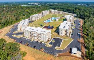 an aerial view of an apartment complex with buildings and a parking lot