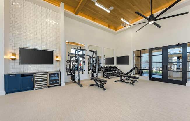 A spacious gym with a variety of equipment and a flat screen TV.