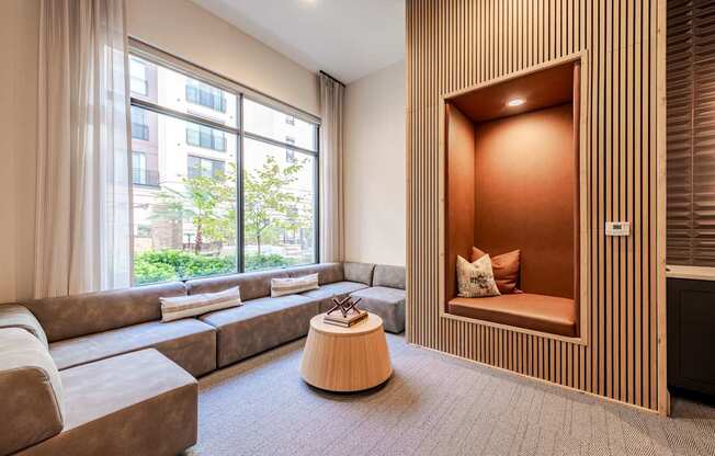 A modern living sitting nook with a large window and a wooden accent wall.