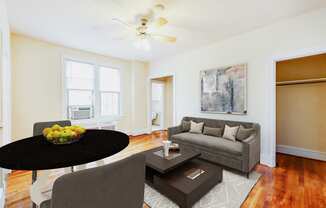 living area with sofa, coffee table, hardwood floors and large windows at 1818 riggs apartments in washington dc