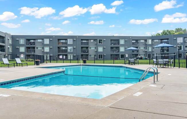 A swimming pool in front of apartment buildings.