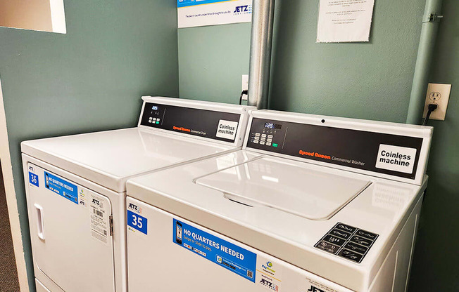 Two coinless machines are in a room with green walls.