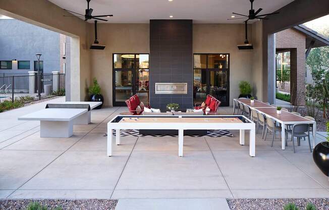 an outdoor patio with tables and chairs and a fireplace