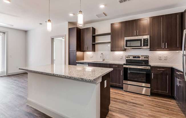 A modern kitchen with dark wood cabinets and stainless steel appliances.
