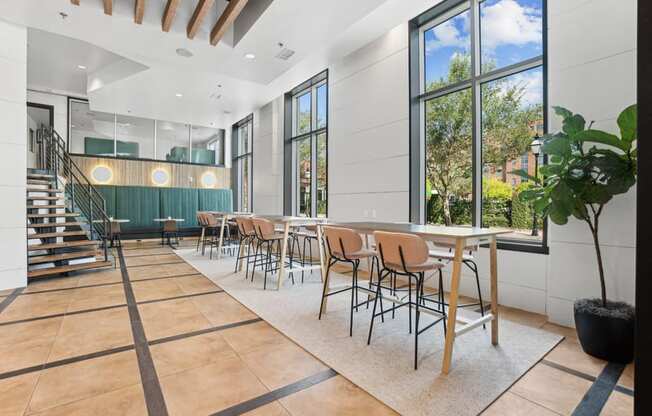 a dining room with tables and chairs and large windows