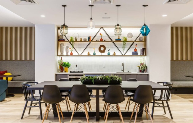a dining area with a table and chairs and a kitchen in the background at One Ten Apartments, New Jersey, 07310