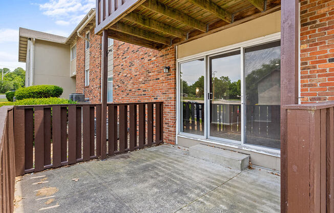 a balcony with a wooden deck and a brick building