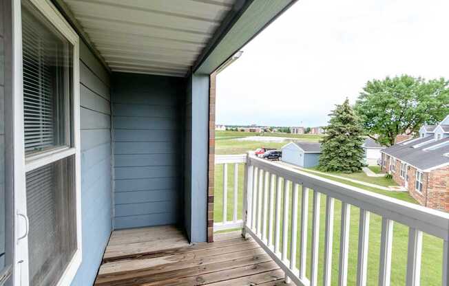 a balcony with a view of a yard and a house at Creekstone Falls, Sioux Falls, SD