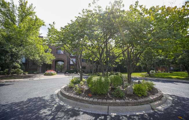 a roundabout with trees and plants in the middle of a street