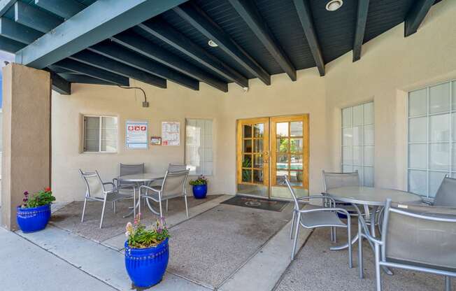 a patio with tables and chairs outside of a building