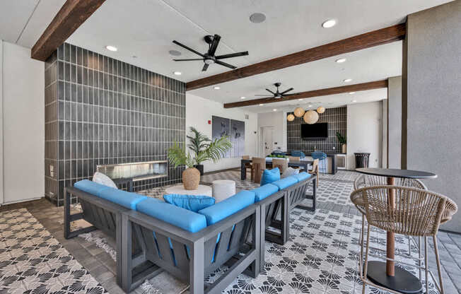 A modern living room with a blue couch and a black and white tiled floor.