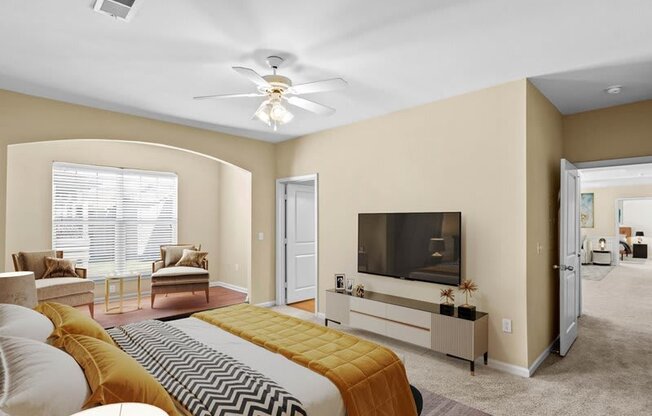 a living room with a bed and a ceiling fan