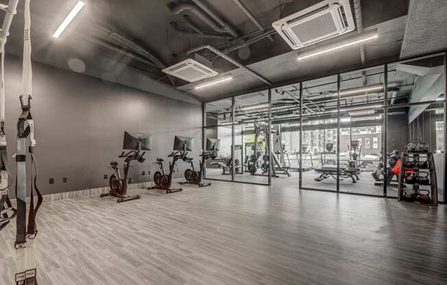 a gym with weights and exercise equipment in a glass walled room