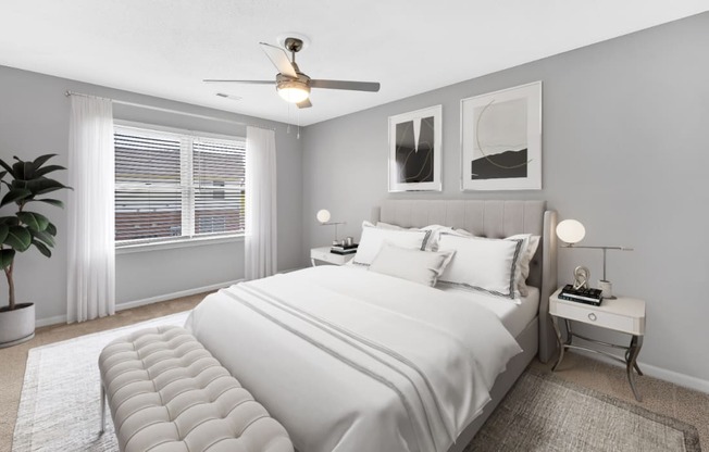 a white bedroom with a large bed and a ceiling fan