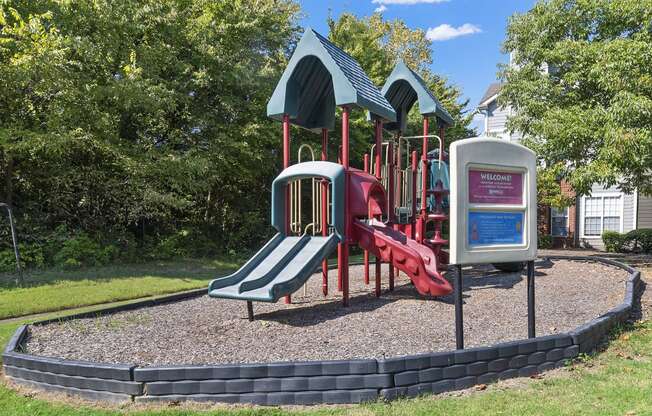 a playground with a red slide and a blue and red