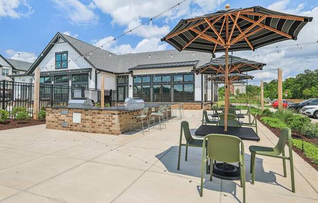 a patio with tables and umbrellas and a building in the background