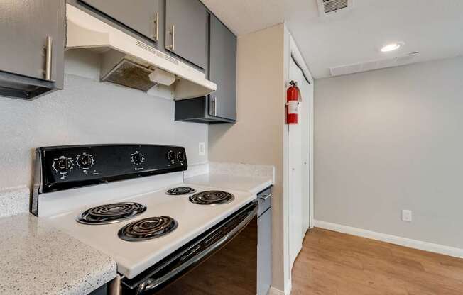 A white stove top oven with four burners and a white counter top.