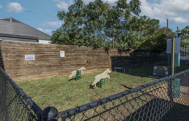 A park with a fence and a sign on a wooden wall.