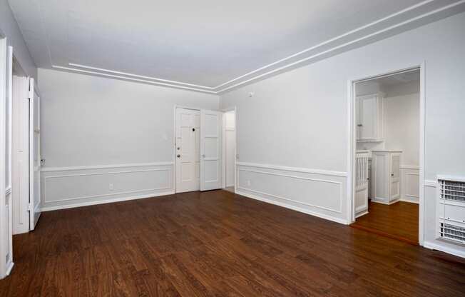 a bedroom with hardwood floors and white walls