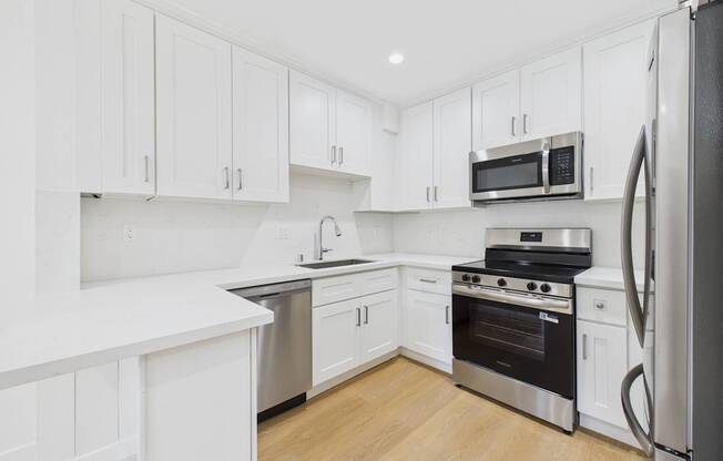 A kitchen with white cabinets and stainless steel appliances.